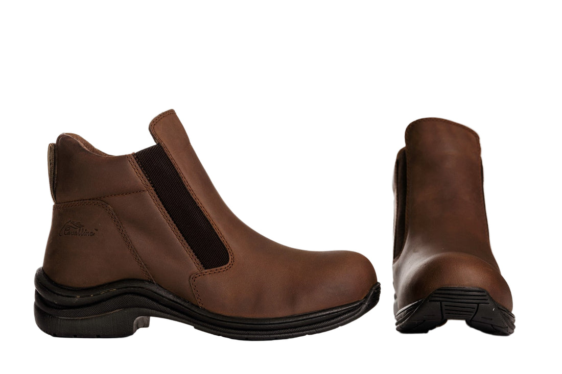 Brown ankle boots with black soles on a white background